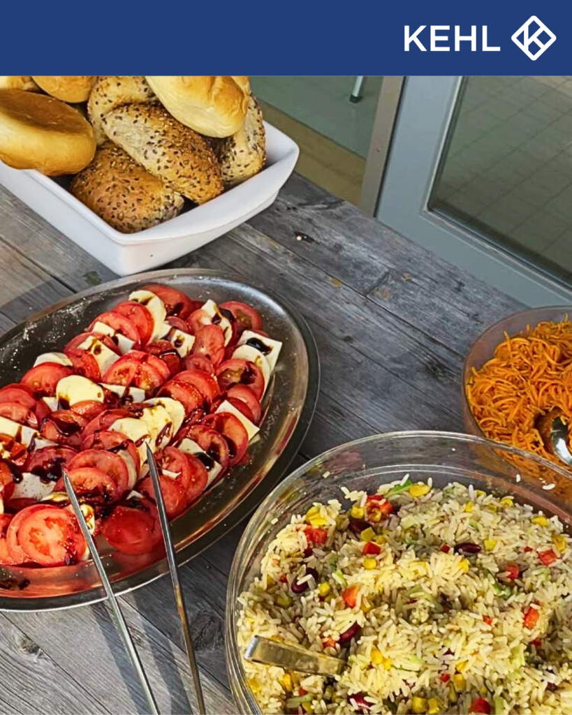 Verschiedene Salate und Brötchen auf einem Tisch.